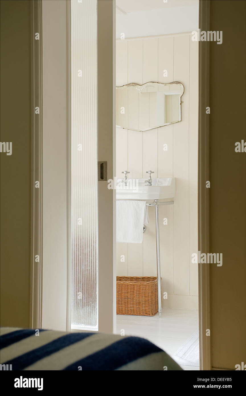 View through sliding door to paneled en suite bathroom Stock Photo