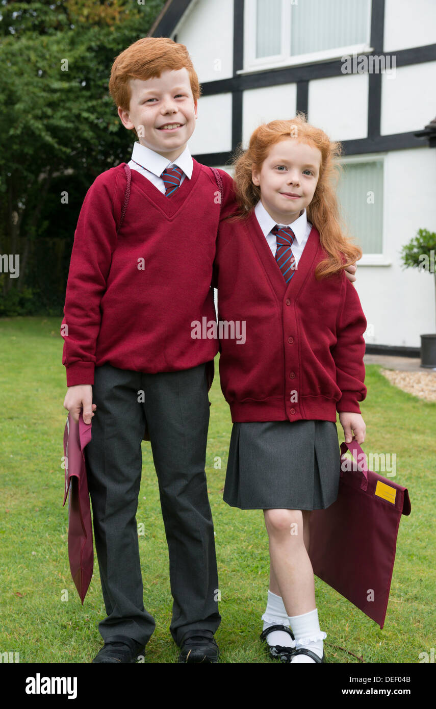 Brother and sister in their school uniform outside their home. Stock Photo