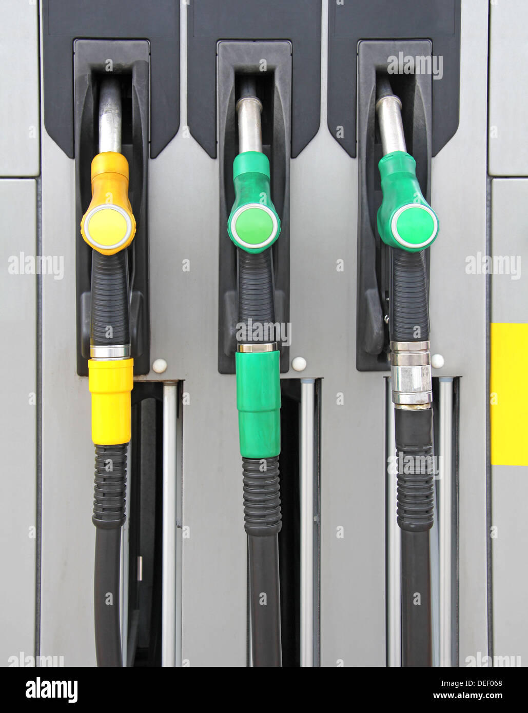 Yellow and green Pump nozzles at the gas station Stock Photo