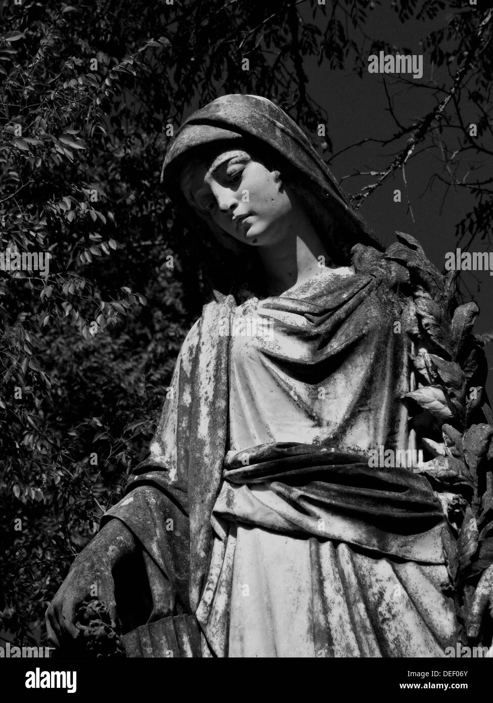 A stone statue of a angel marks a grave site. Stock Photo