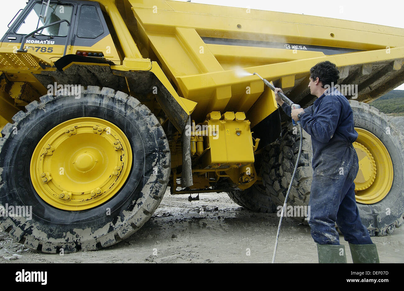 Worker cleaning dumpertruck to carry marl from quarry to cement plant