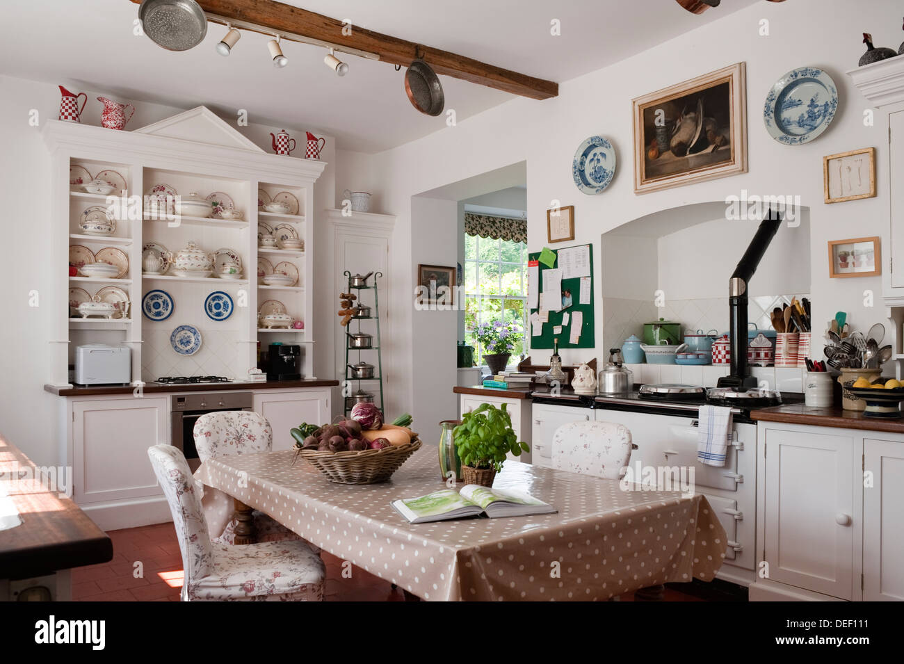 https://c8.alamy.com/comp/DEF111/farmhouse-kitchen-with-ceramics-display-and-open-recipe-book-on-table-DEF111.jpg