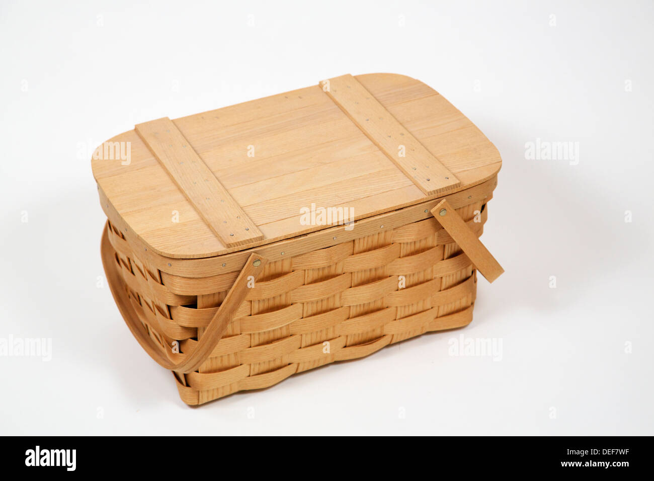 Woven wooden picnic basket on white background. Still life. Stock Photo