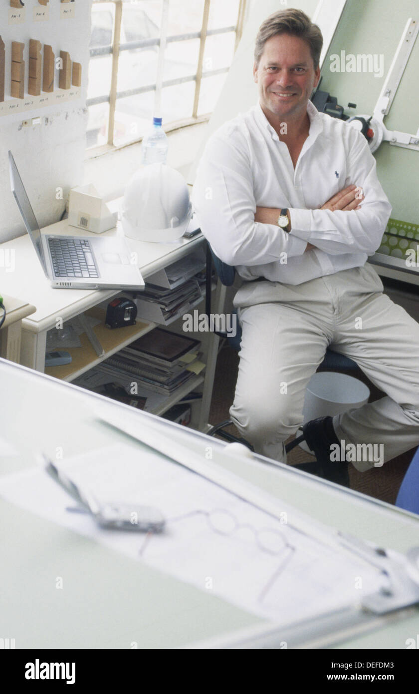 Young man in design studio sitting at draughting table. Proud small business owner Stock Photo