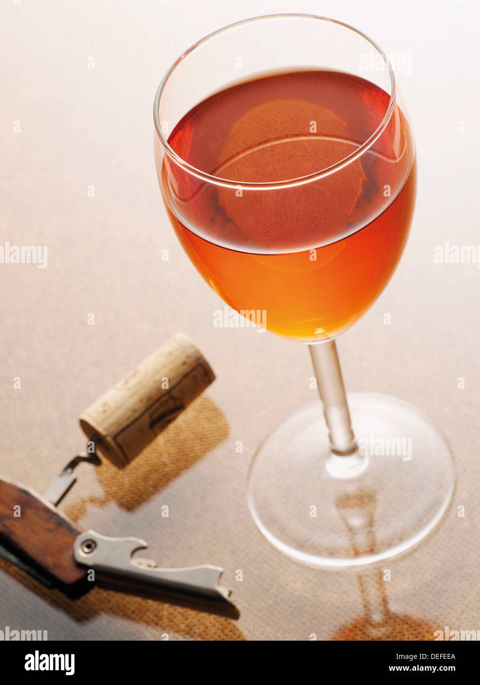 Glass of rose wine beside a corkscrew with a cork Stock Photo Alamy