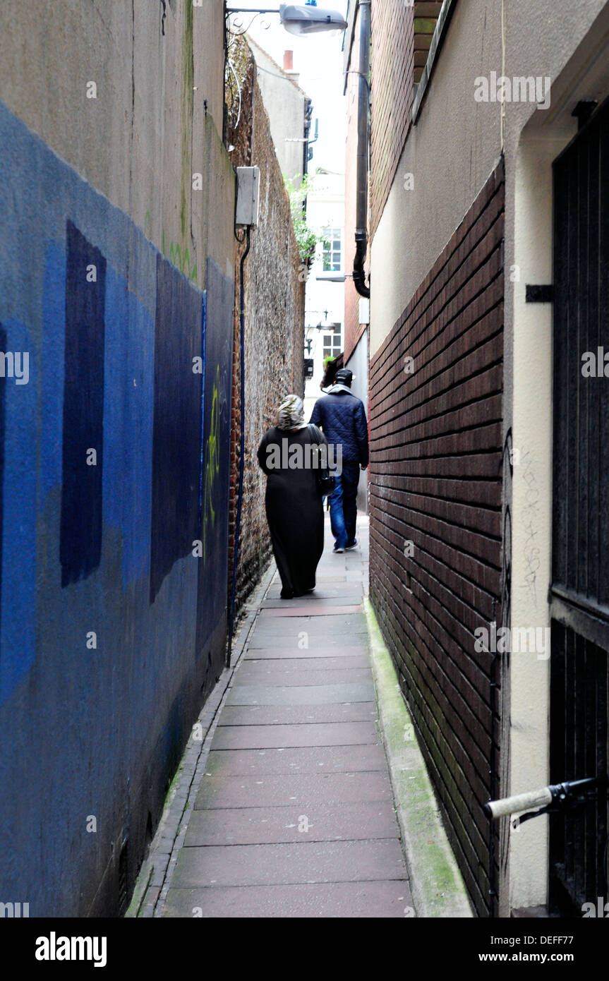 A rear view of a Muslim woman walking in an alleyway, Brighton, UK Stock Photo