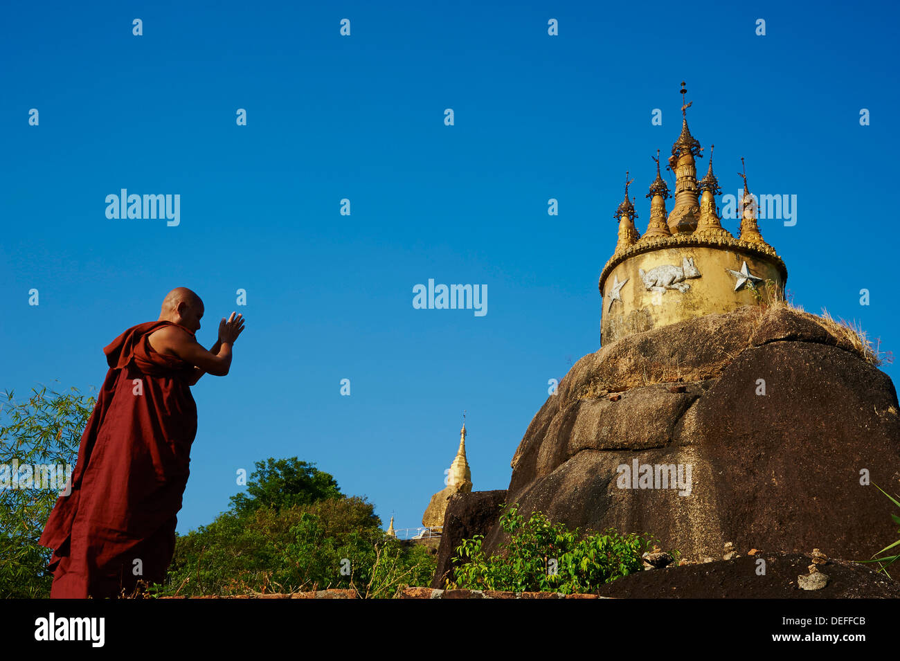 Buddhist monk praying at the Golden Rock of Nwa La Bo, Mawlamyine (Moulmein), Mon State, Myanmar (Burma), Asia Stock Photo