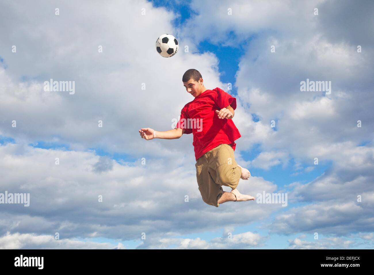 Hitting soccer ball high in the sky Stock Photo Alamy