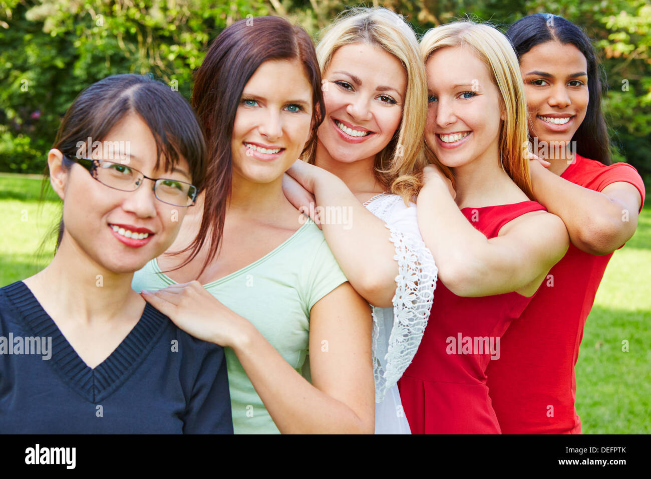 Team of five happy young women smiling in nature Stock Photo