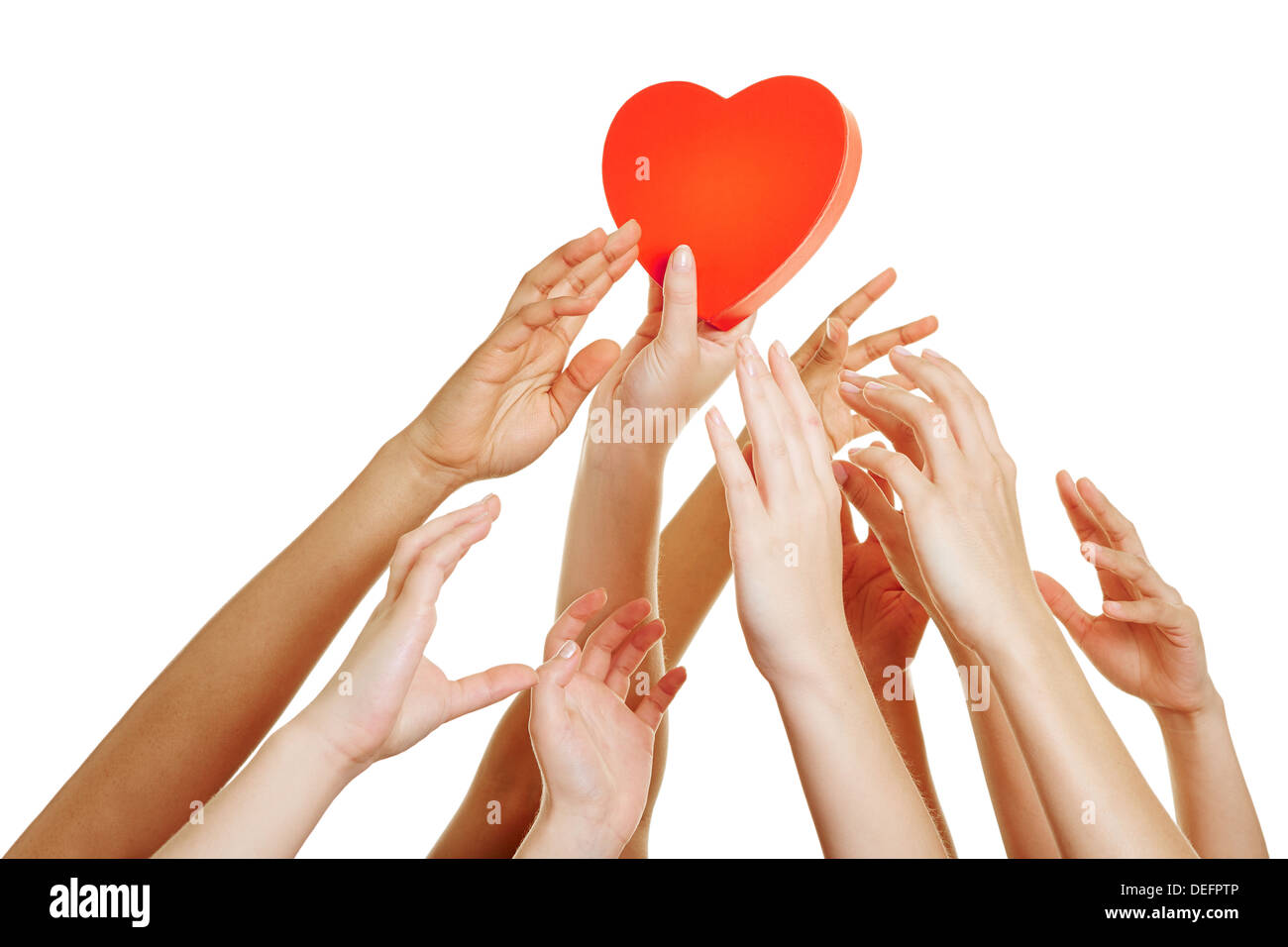 Many hands reaching for red heart as symbol for dating Stock Photo