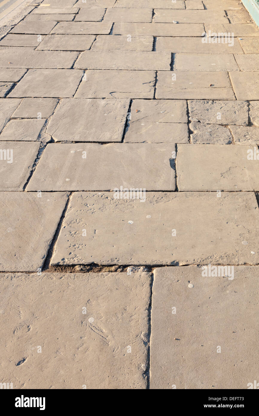 Uneven pavement with old paving slabs, England, UK Stock Photo