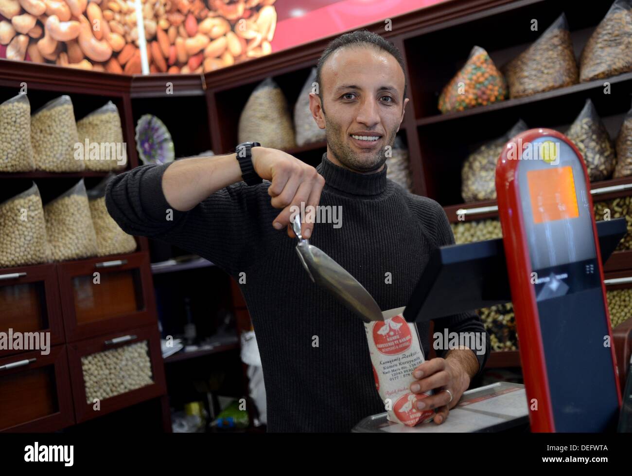 Ahmet Ucar weighs nuts in his store in Berlin, Germany, 13 September 2013. Many Turkish people and people with Turkish heritage are following the elections in Germany. Photo: BRITTA PEDERSEN Stock Photo