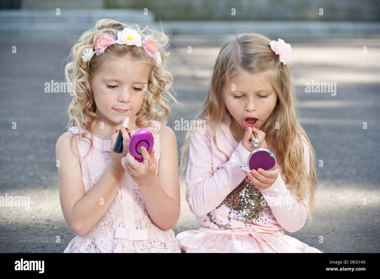 Two young preteen girls wearing pink and putting make up on. Stock Photo