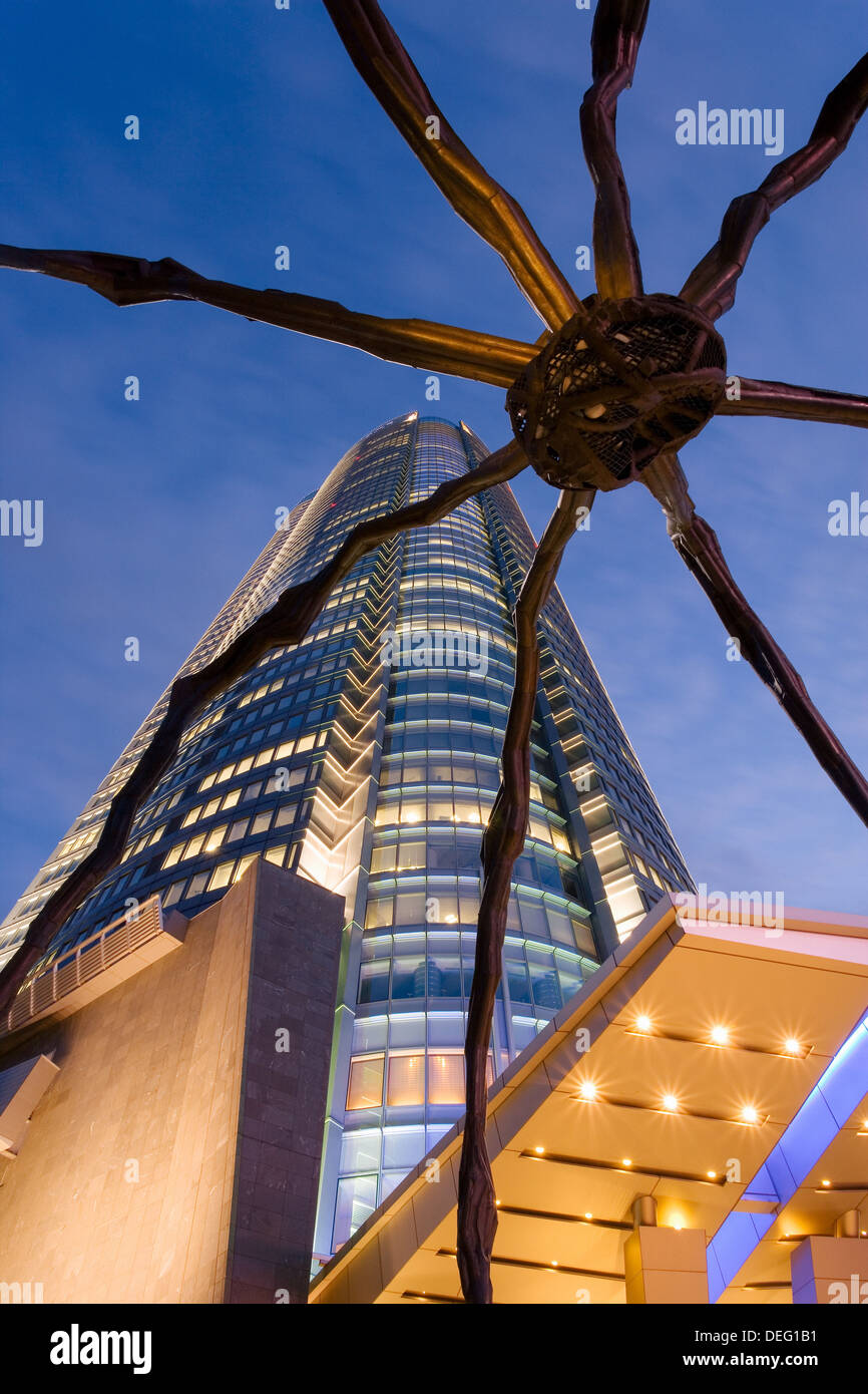 Low angle view at dusk of Mori Tower and Maman Spider sculpture, Roppongi Hills, Minato Wad, Tokyo, Honshu, Japan, Asia Stock Photo