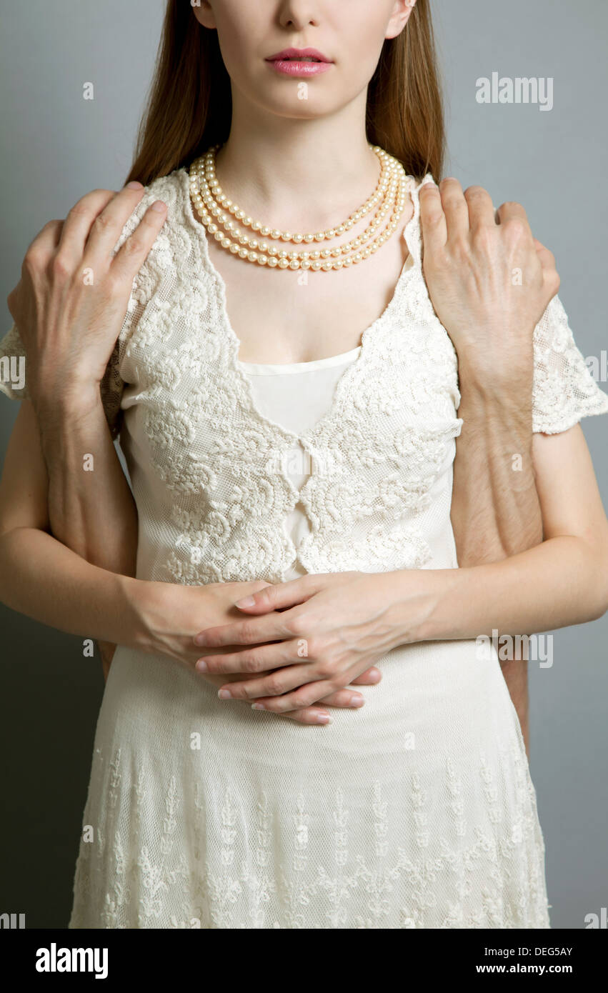 Woman in Pale Lace Dress with Man's Hands Stock Photo