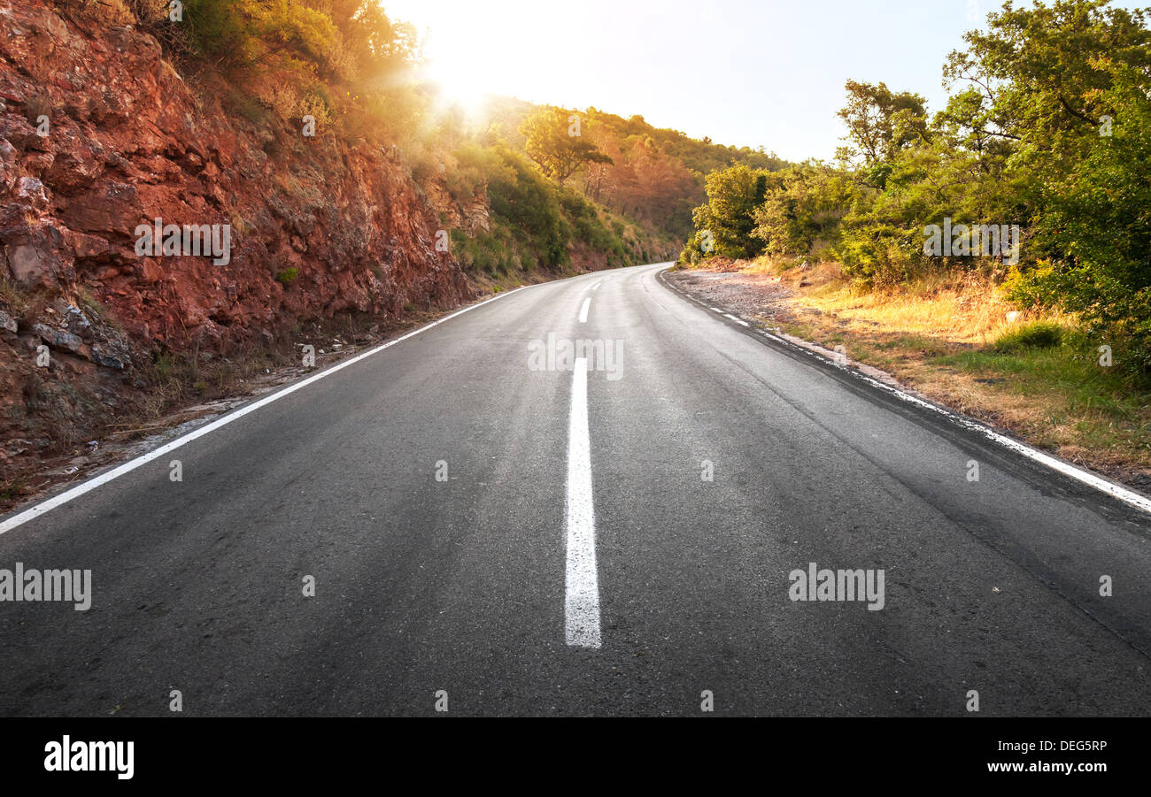 Empty rural asphalt highway perspective with bright shining sun Stock Photo