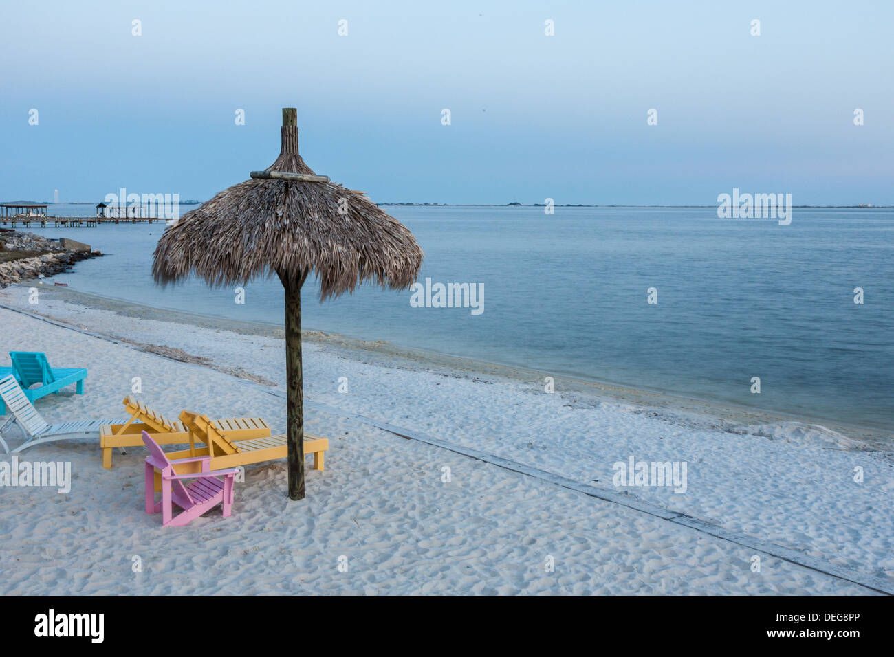 Brightly painted wooden beach chairs on the white sand beach of Santa Rosa Sound in Navarre, Florida Stock Photo