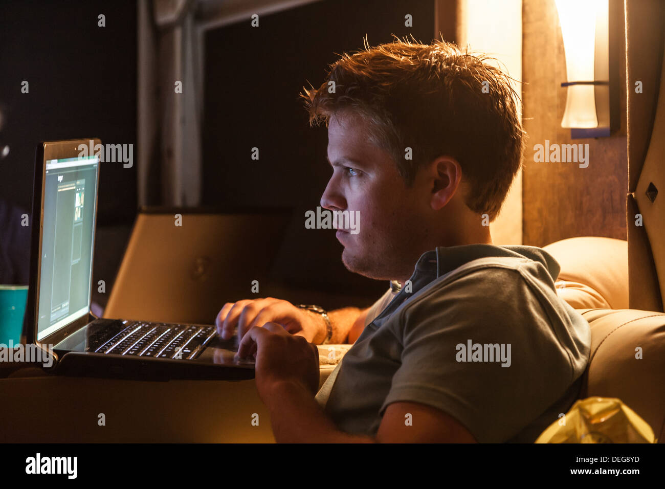 Young man working on laptop in the dark Stock Photo - Alamy