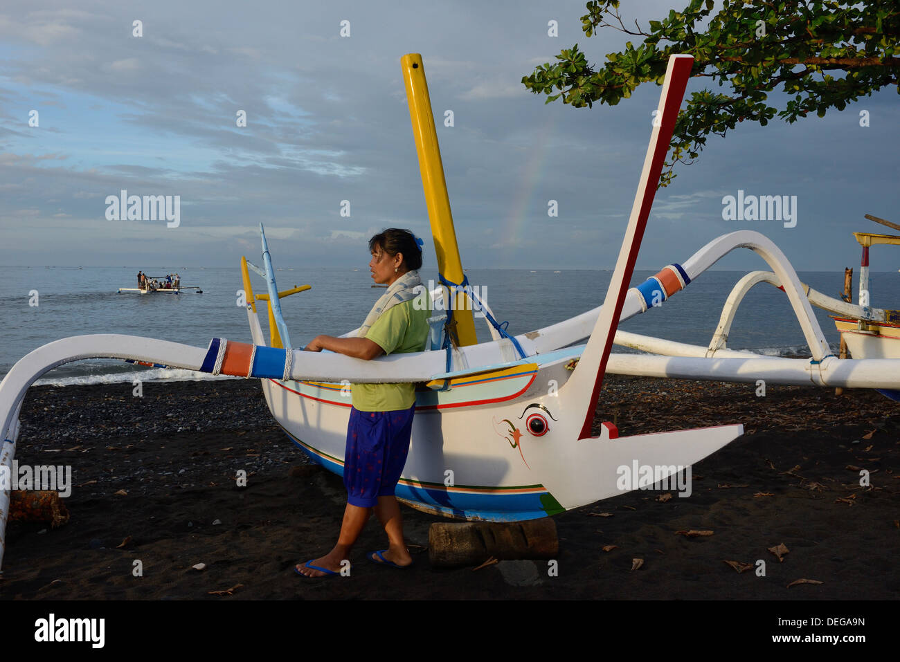 Indonesia, island of Bali, Amed village, woman waiting on the beach for the return of the fishing boat Stock Photo