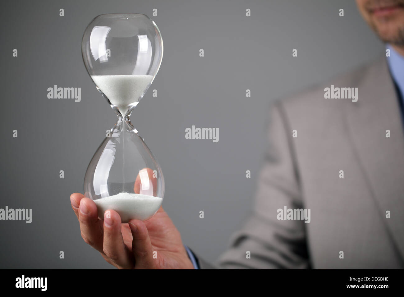 Businessman holding hourglass Stock Photo