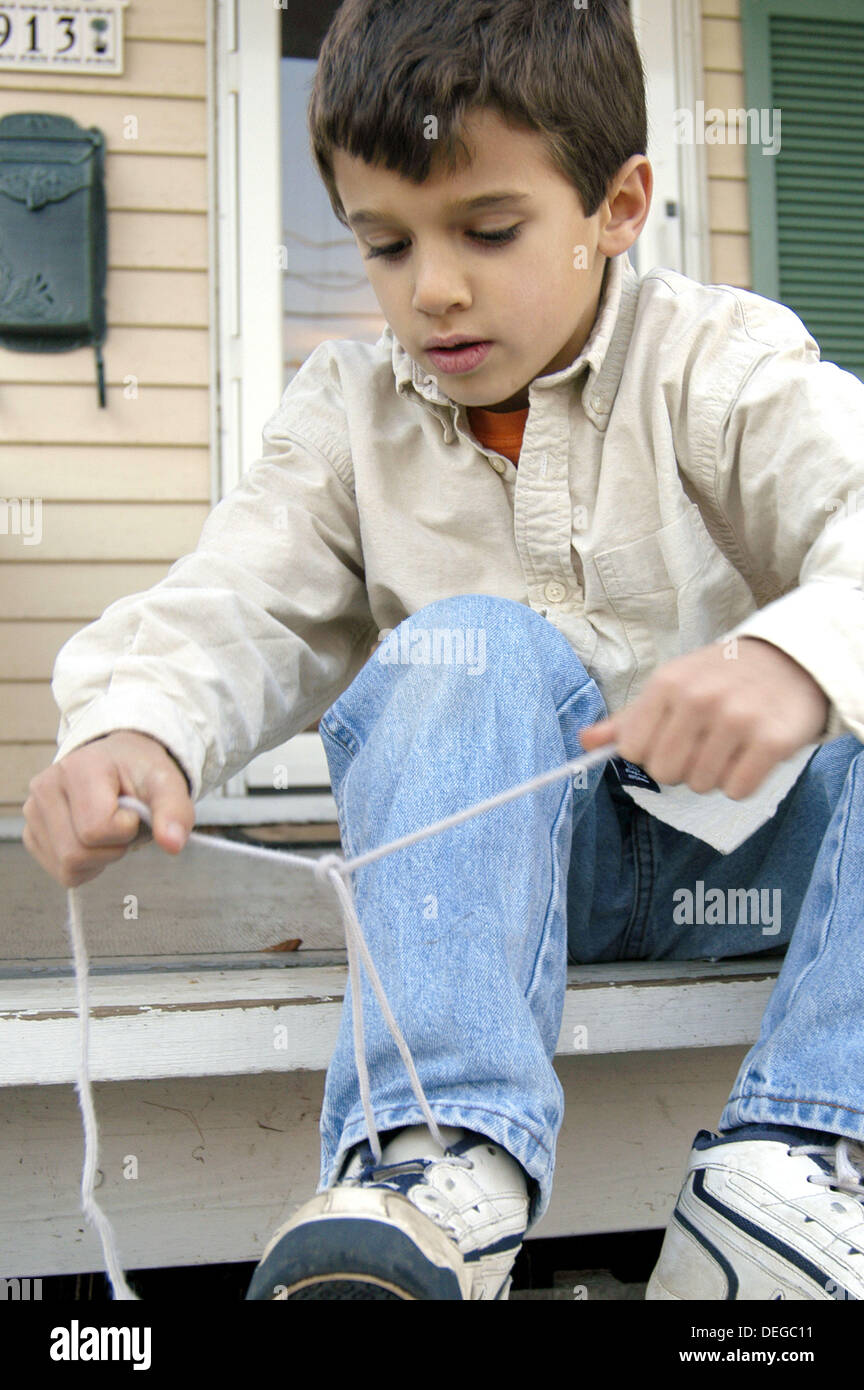 Four years old boy learning to tie shoes Stock Photo Alamy