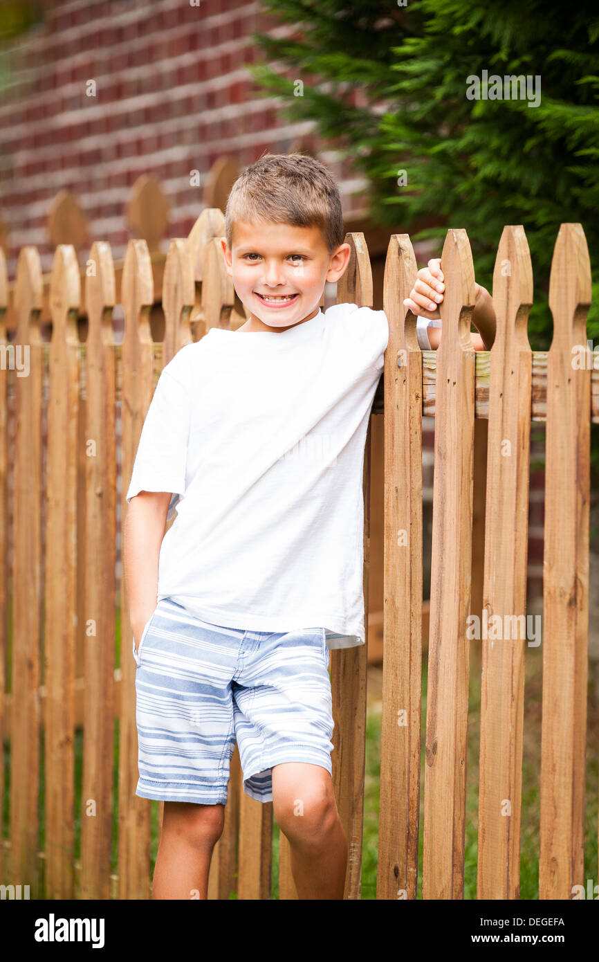 boy leaning on a wooden fence Stock Photo