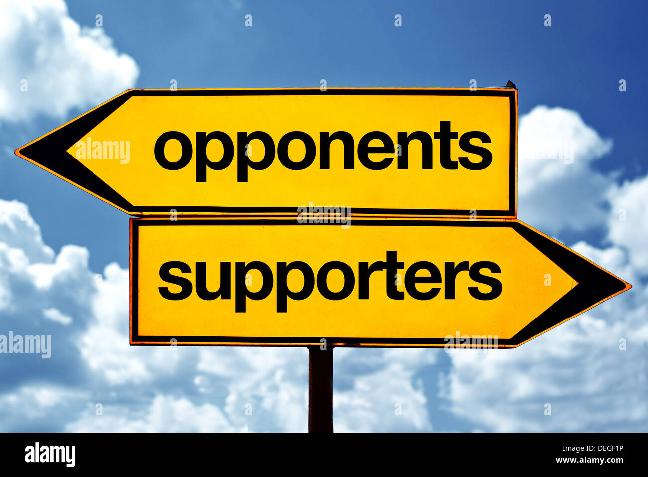 Opponents or supporters opposite signs. Two opposite road signs against blue sky background. Stock Photo