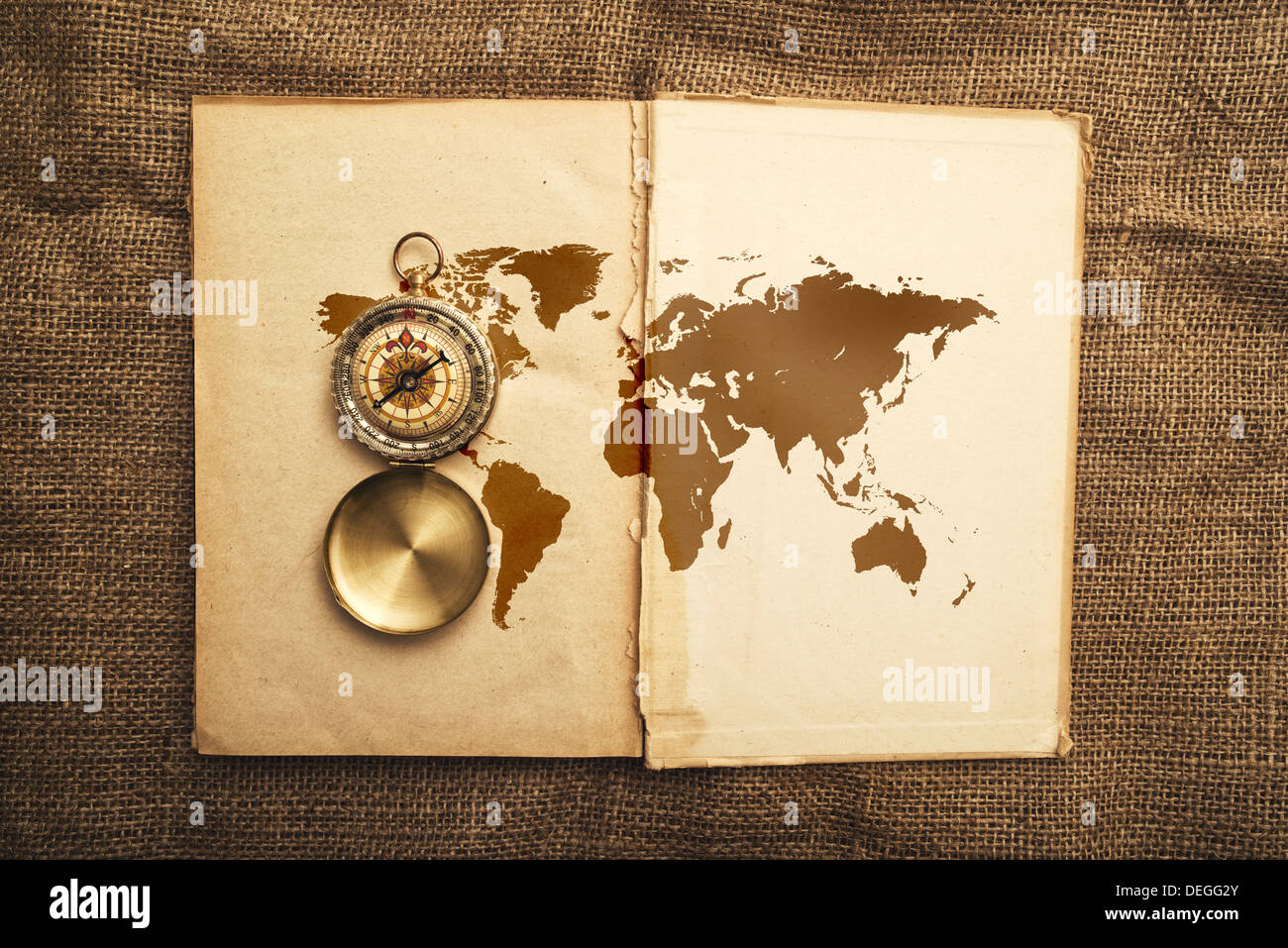 Vintage open book with old navigation compass and world map. Stock Photo