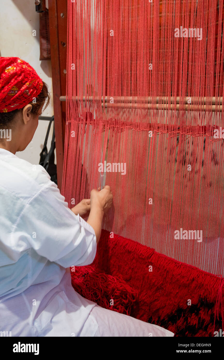 woman in Morocco is weaving a carpet Stock Photo