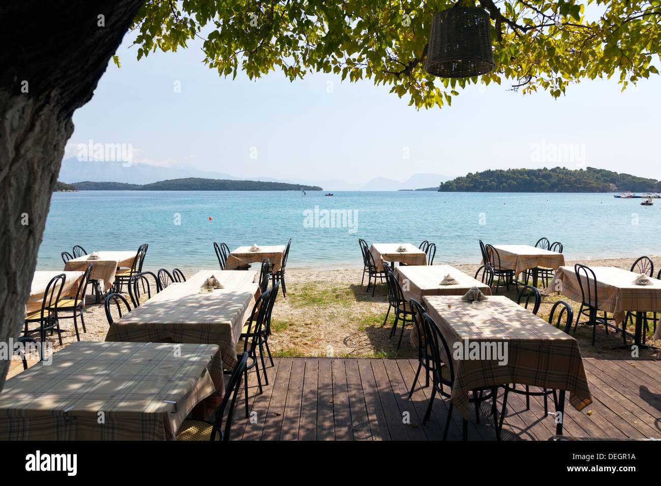 Typical taverna restaurant by beach coast sea Nydri Nidri Lefkas Lefkada Greek Island Greece tables Stock Photo
