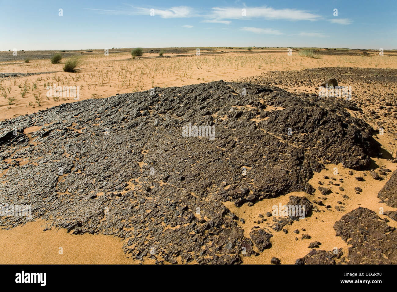 Area in Sahara Desert showing very ancient weathered surface of black Laterite rock, with secondary 'top' capping or leach cap Stock Photo
