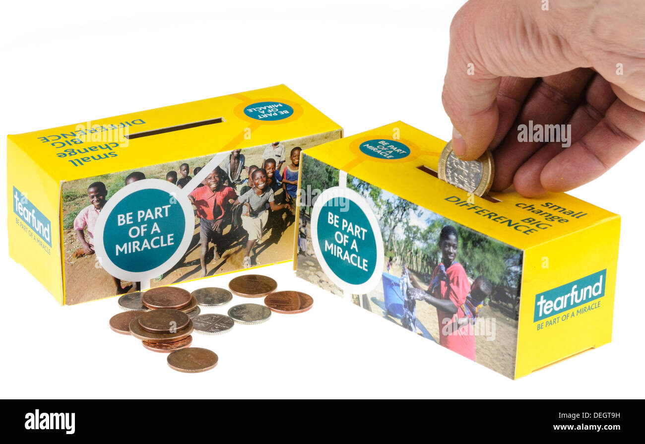 A man inserts money into one of two Tear Fund collection boxes Stock Photo