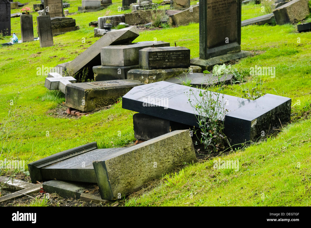 Headstones in a graveyard deliberately laid flat for safety reasons after becoming unstable Stock Photo
