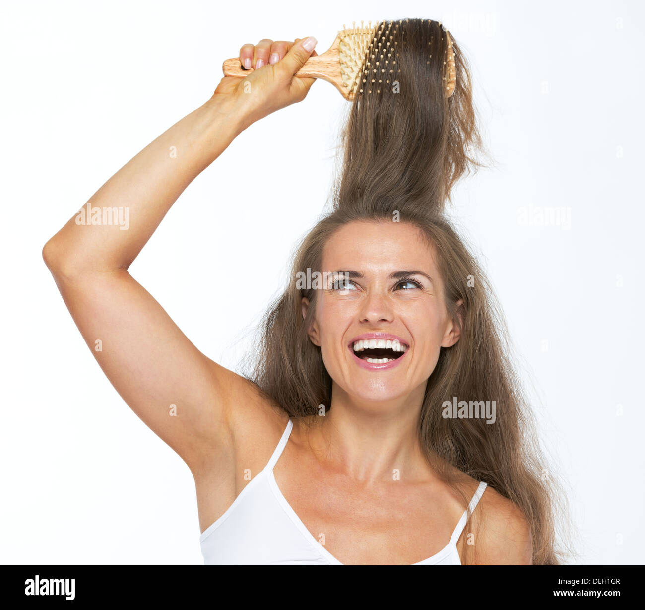 Happy young woman combing hair Stock Photo - Alamy