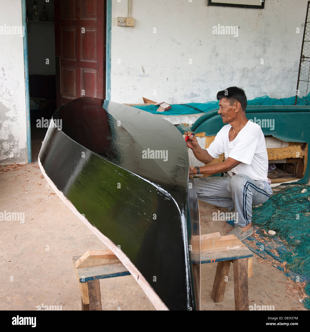 Asian man building a small boat, Labuan, Malaysia Stock Photo