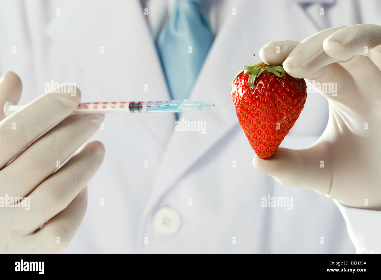Scientist giving strawberry an injection by syringe Stock Photo - Alamy