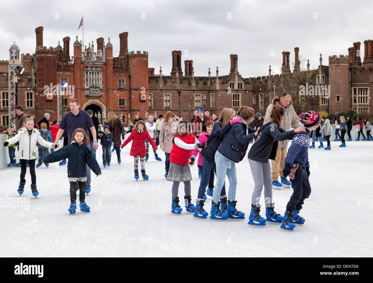 People enjoy Ice skating at temporary winter ice rink in front of Hampton Court Palace, Greater London, UK Stock Photo
