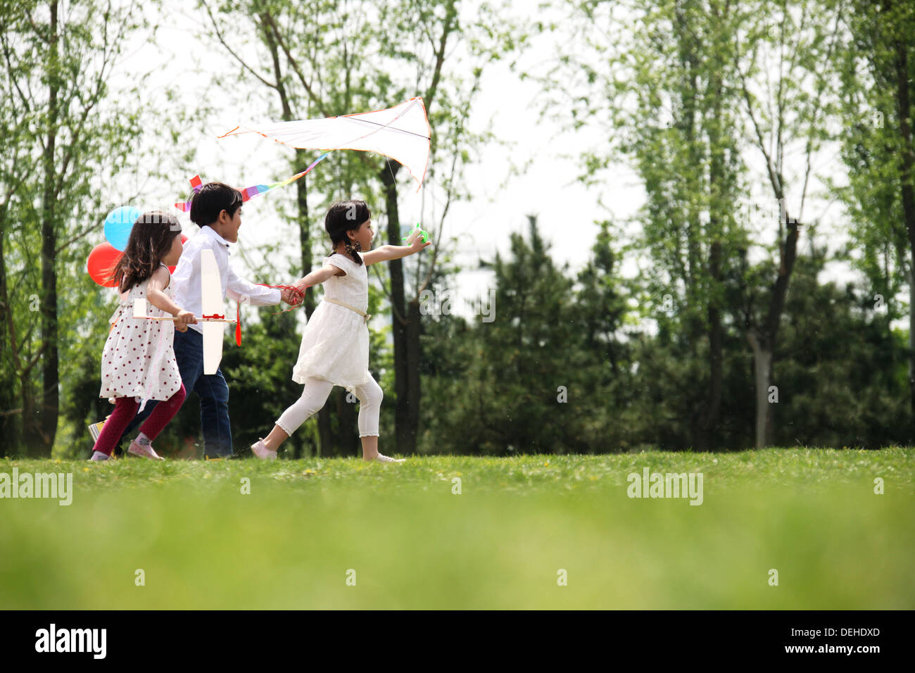 three-children-playing-in-meadow-4-5-years-hi-res-stock-photography-and