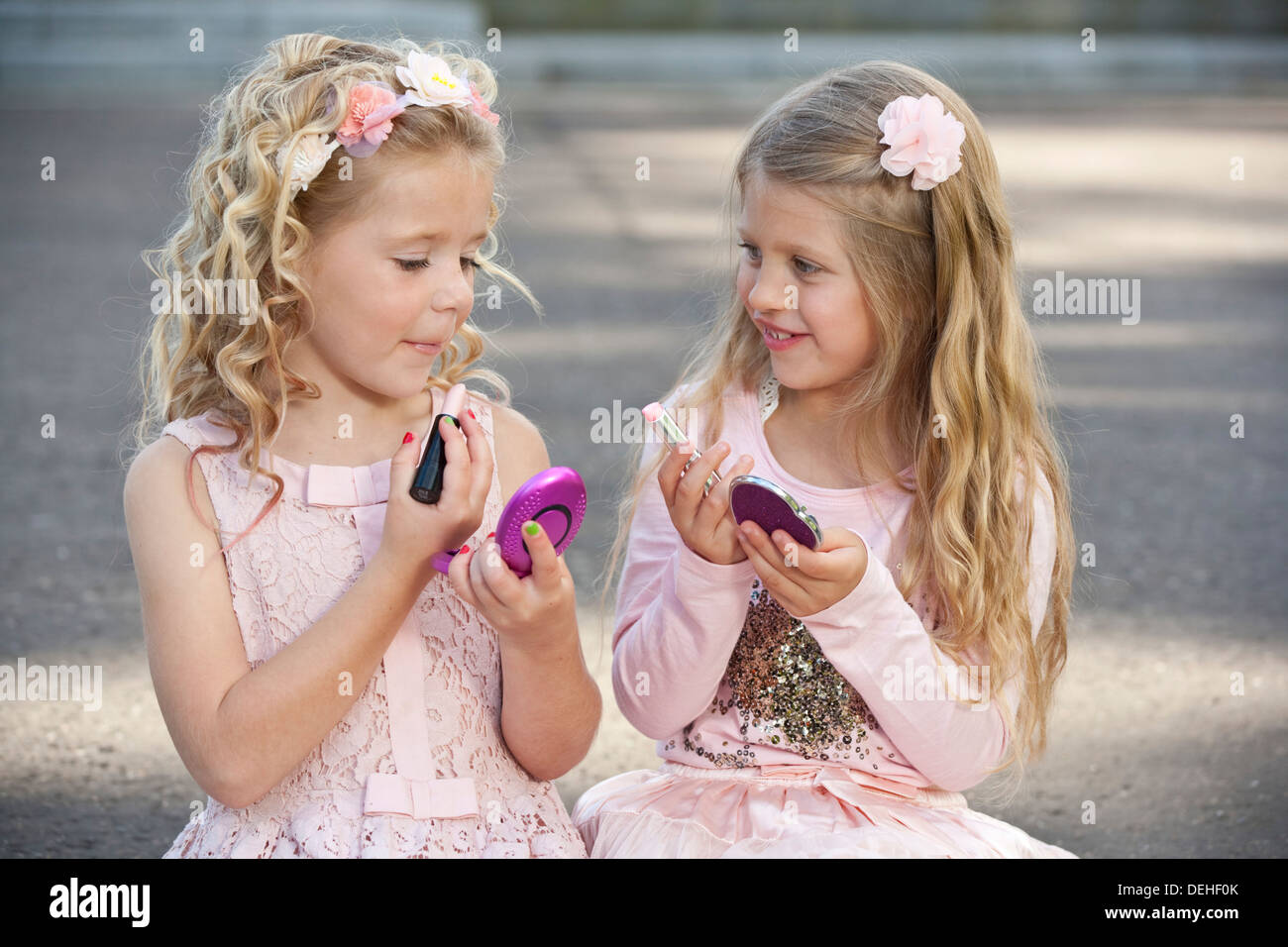 Two young preteen girls wearing pink and putting make up on. Stock Photo