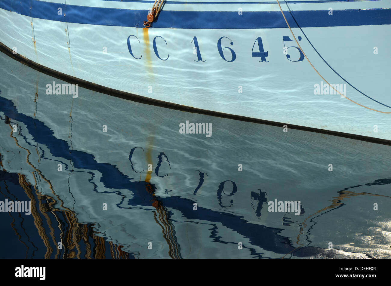 Blue boat reflection on water in the harbour of Concarneau, Brittany, France. Stock Photo