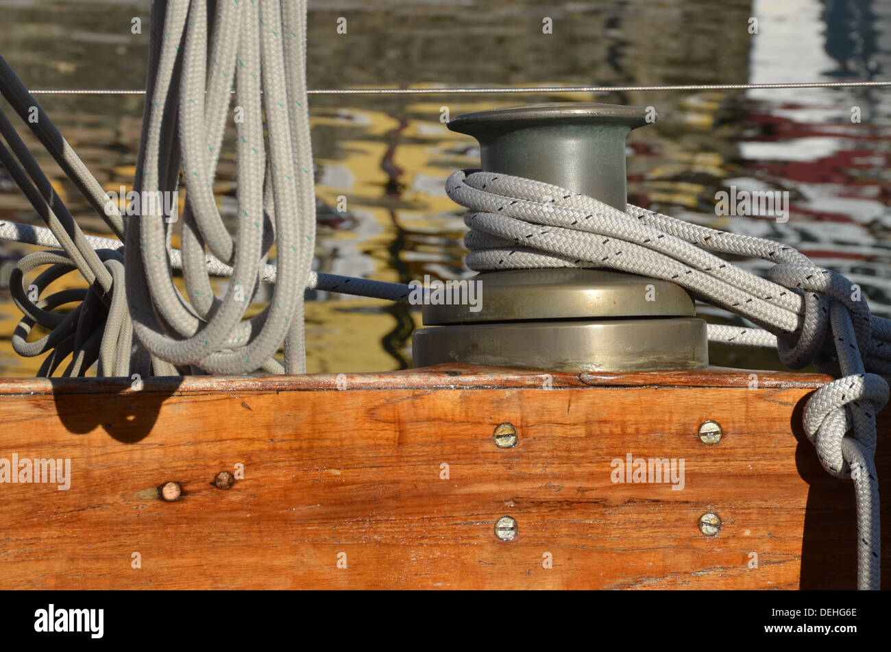 Close view of a vintage boat deck with a winch and ropes in the harbour