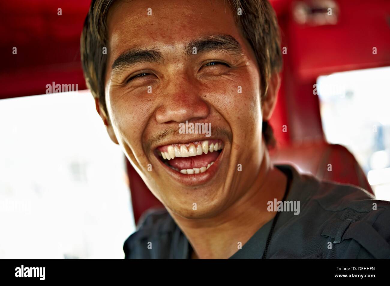 Jeepney driver laugh and look in camera  Mandaluyong City  Metro Manila  Philippines Stock Photo