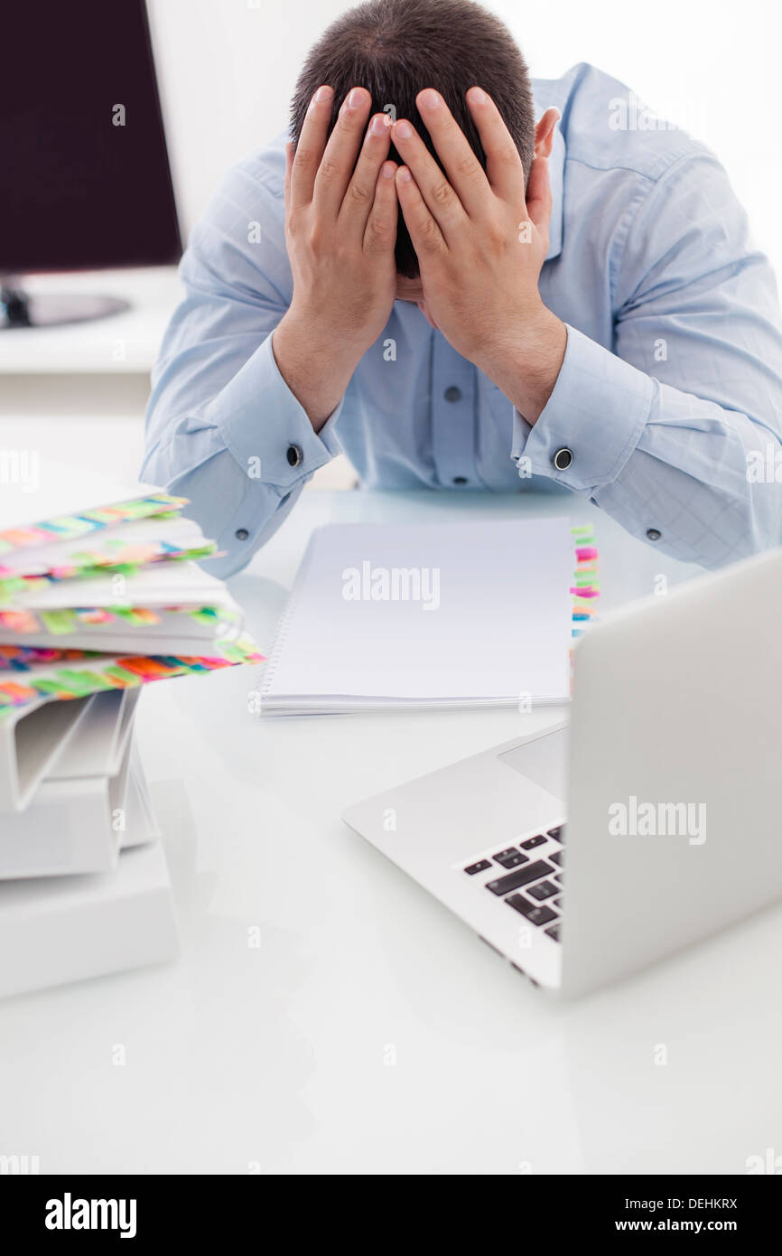Closeup view Caucasian businessman with heads hands his desk Stock