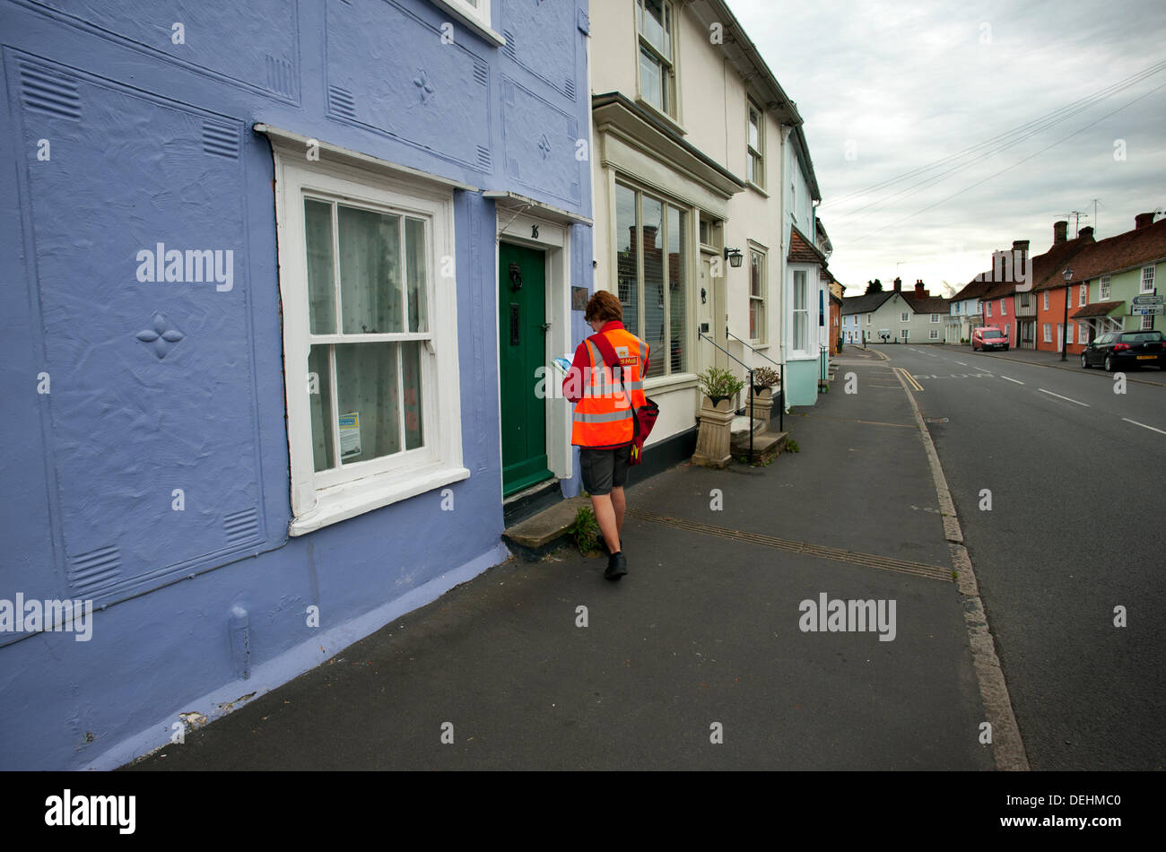 Royal Mail Post delivery, Thaxted, Essex, England. 19-9-2013 Royal Mail Postwoman delivers the morning post in medieval Thaxted, Essex, England. Royal Mail is due to be privatised in a government backed floatation within weeks. Stock Photo