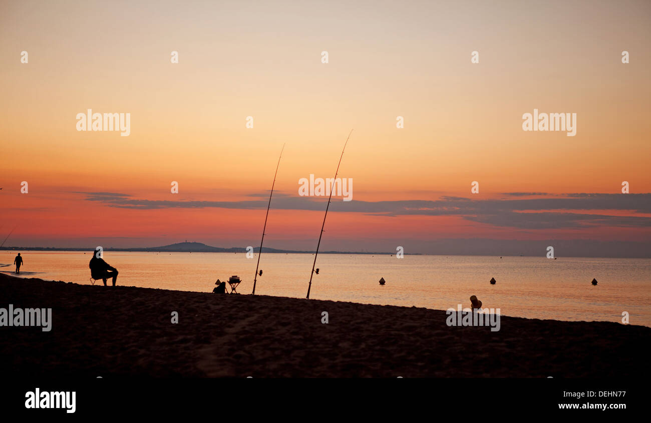 Silhouette of fishermen at sea by sunset Stock Photo - Alamy