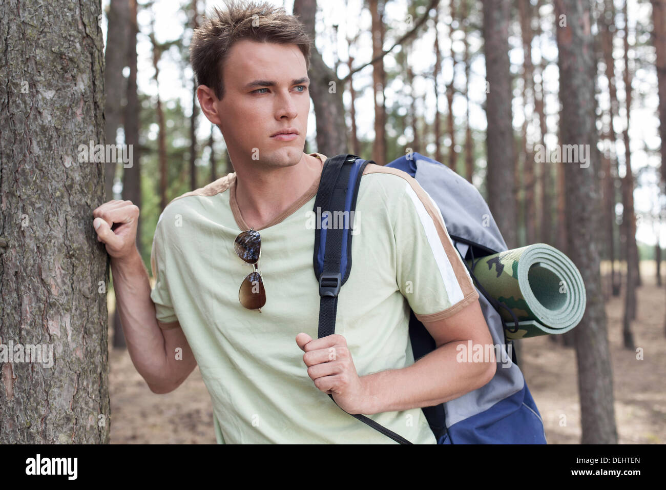 Handsome young man with backpack hiking forest Stock Photo