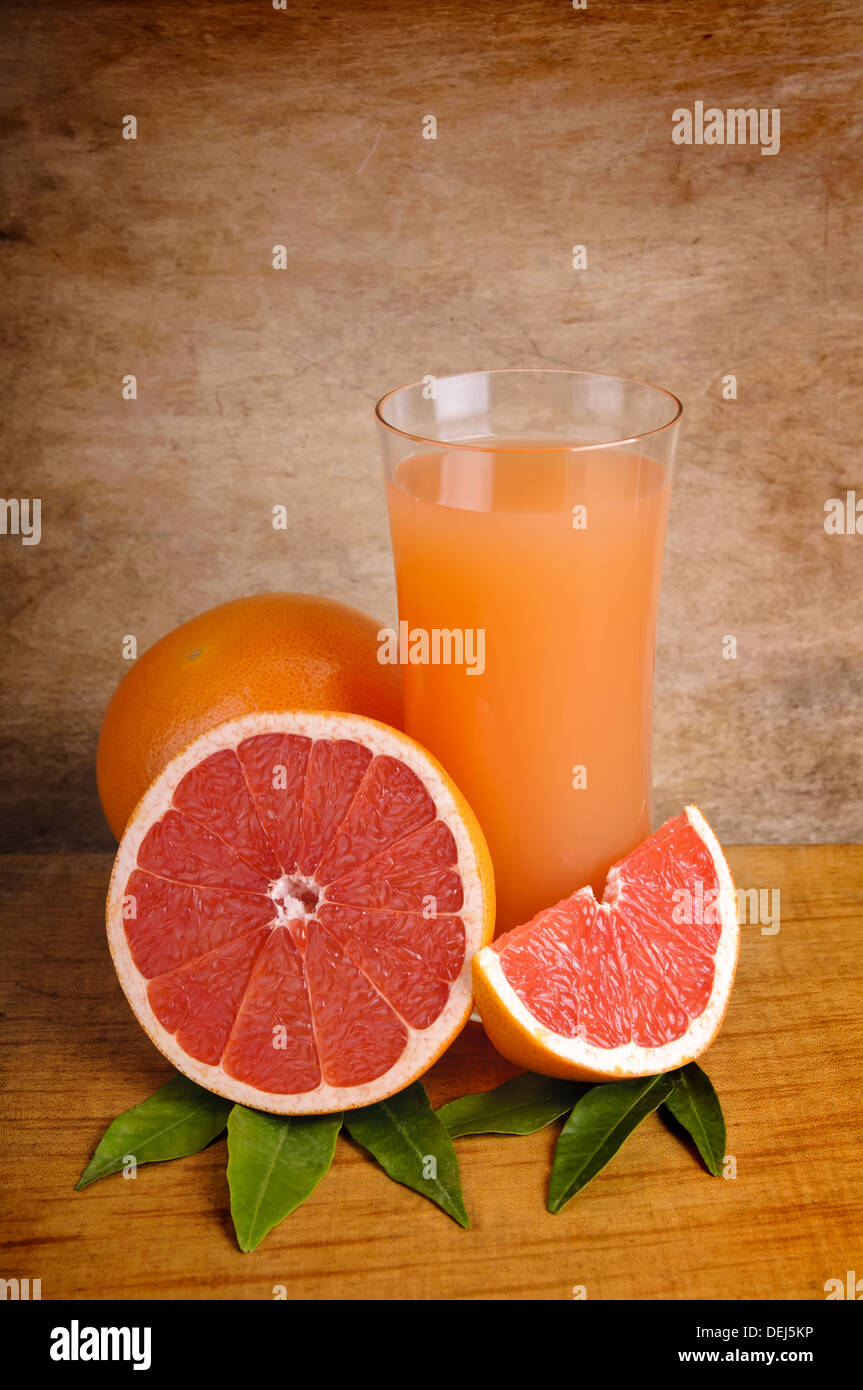 glass of fresh ink grapefruit juice and grapefruits on a wooden background Stock Photo