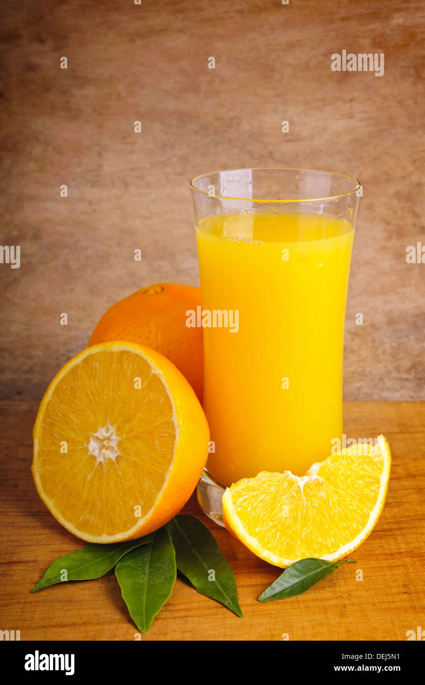 glass of fresh orange juice and oranges on a wooden background Stock ...