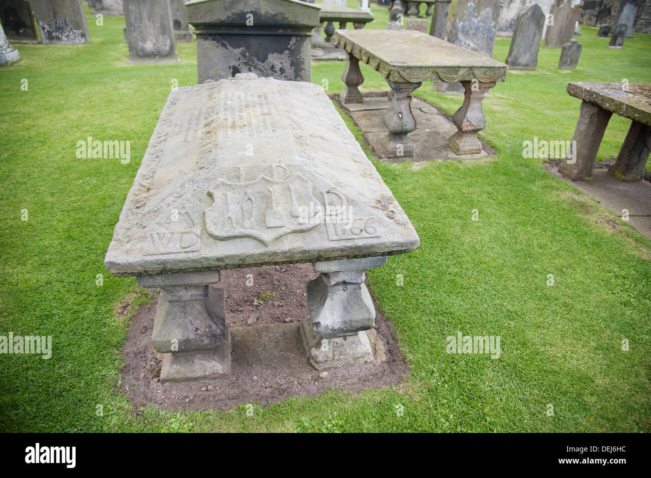 A grave in St Andrews Cathedral graveyard with a raised grave stone and ornate inscription. Stock Photo