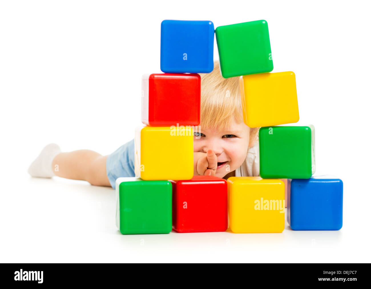 baby boy hidden behind building blocks Stock Photo